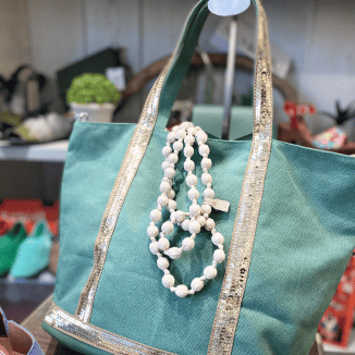 Sac cabas femme vert avec anses dorées et collier blanc décoratif, accessoire tendance en boutique à Salernes