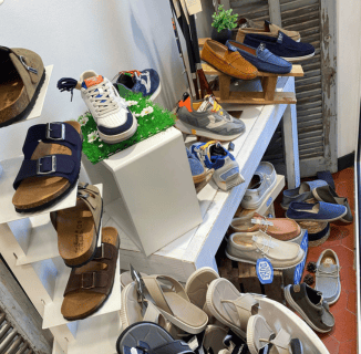 Présentation de chaussures homme et femme en boutique à Salernes, incluant sandales en cuir, baskets et mocassins exposés sur étagères